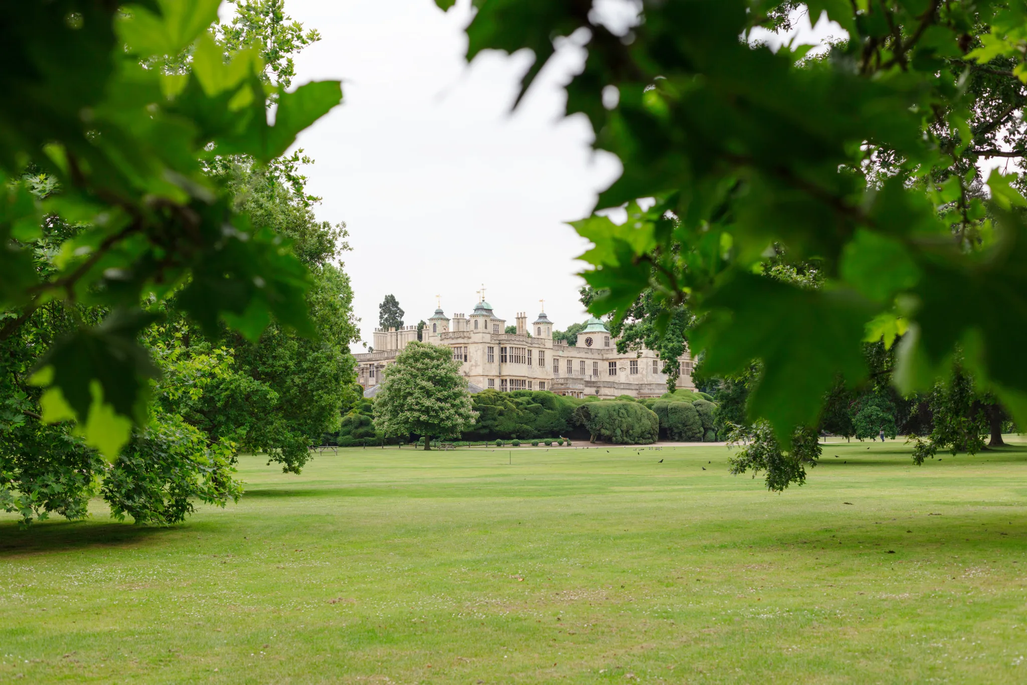 Front facade view through the tree of Audley End House, Saffron Walden CB11 4JF, UK 15th of June 2019